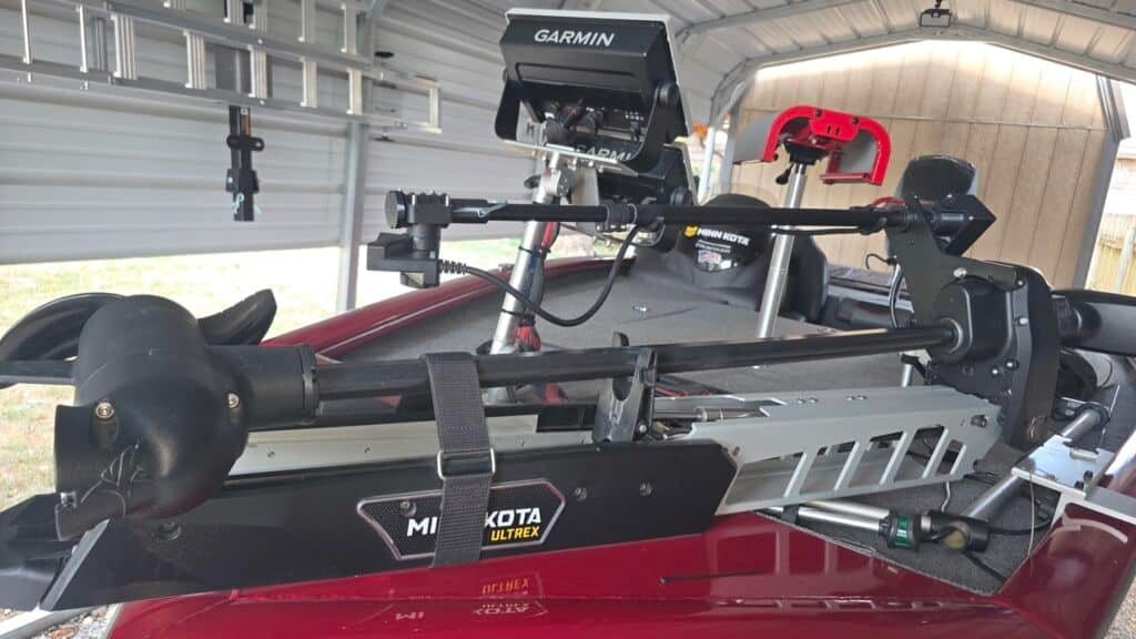 First Mate XT stowed alongside a Minn Kota Ultrex Quest on the bow of a red bass boat under a carport