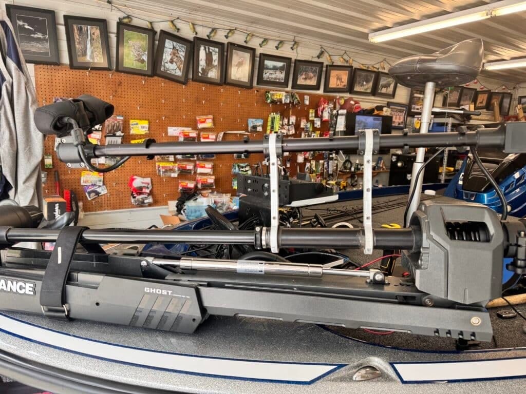 First Mate XT pole stowed flat alongside a Lowrance Ghost trolling motor shaft, held by two dog bone brackets, on a blue bass boat